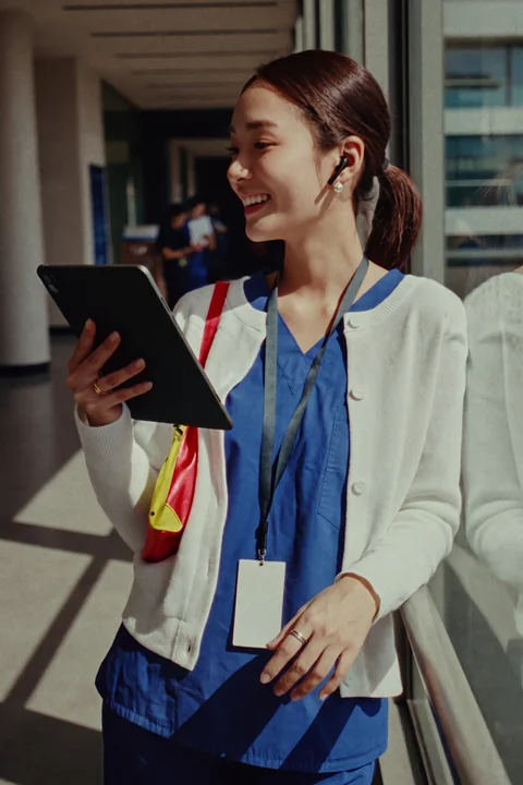 Nurse with a tablet in a bright hospital corridor