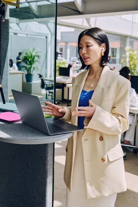 Professional at a laptop explaining a decision in a bright office